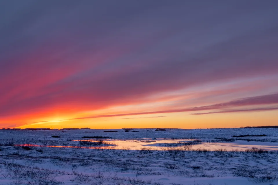 Sonnenuntergang Sonne über bedecktem Schnee