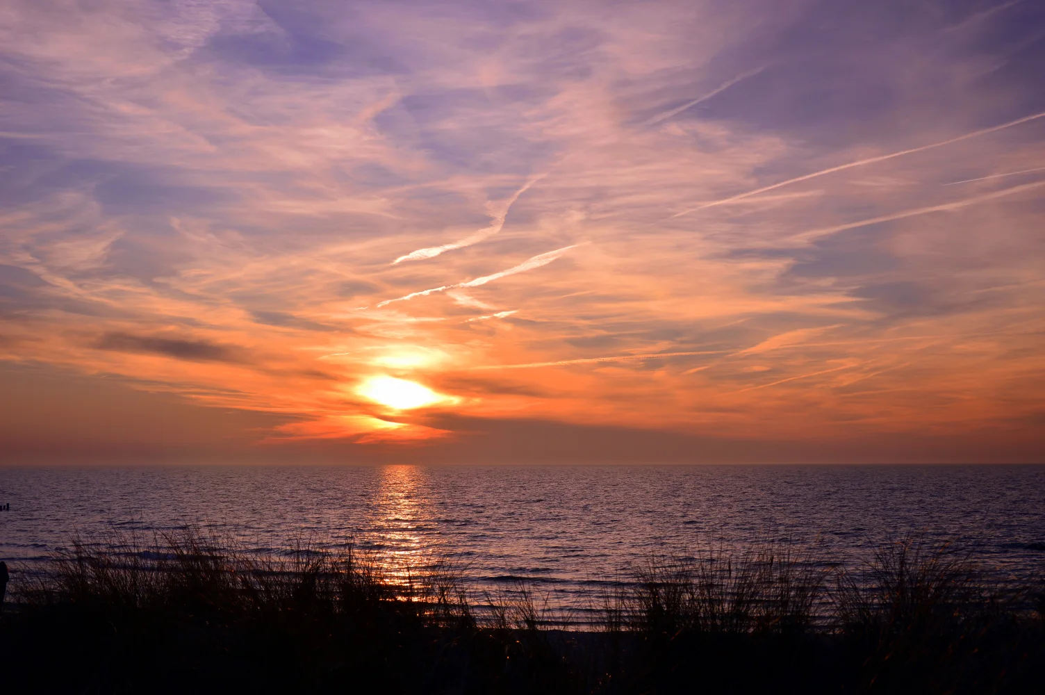 Sonnenuntergang Sonne über ruhigem See im Sommer