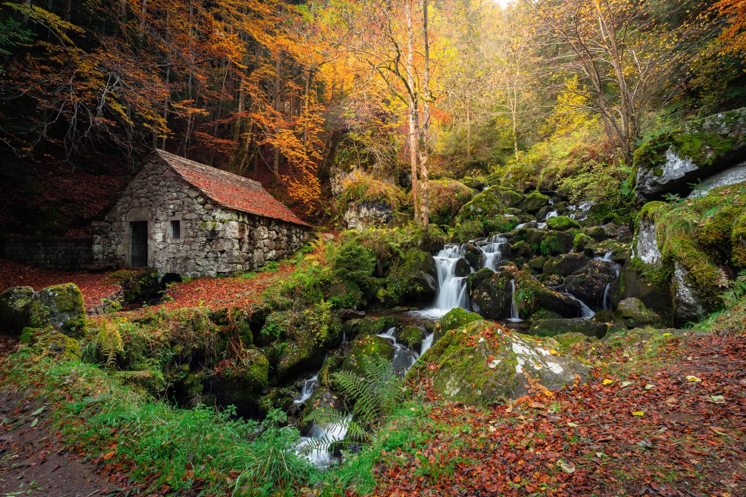 Alter steiniger Haus in herbstlichen Park mit Wasserfall