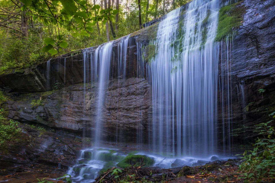 Kalte Wasser Wasserfall fließt entlang Nasser Felsen