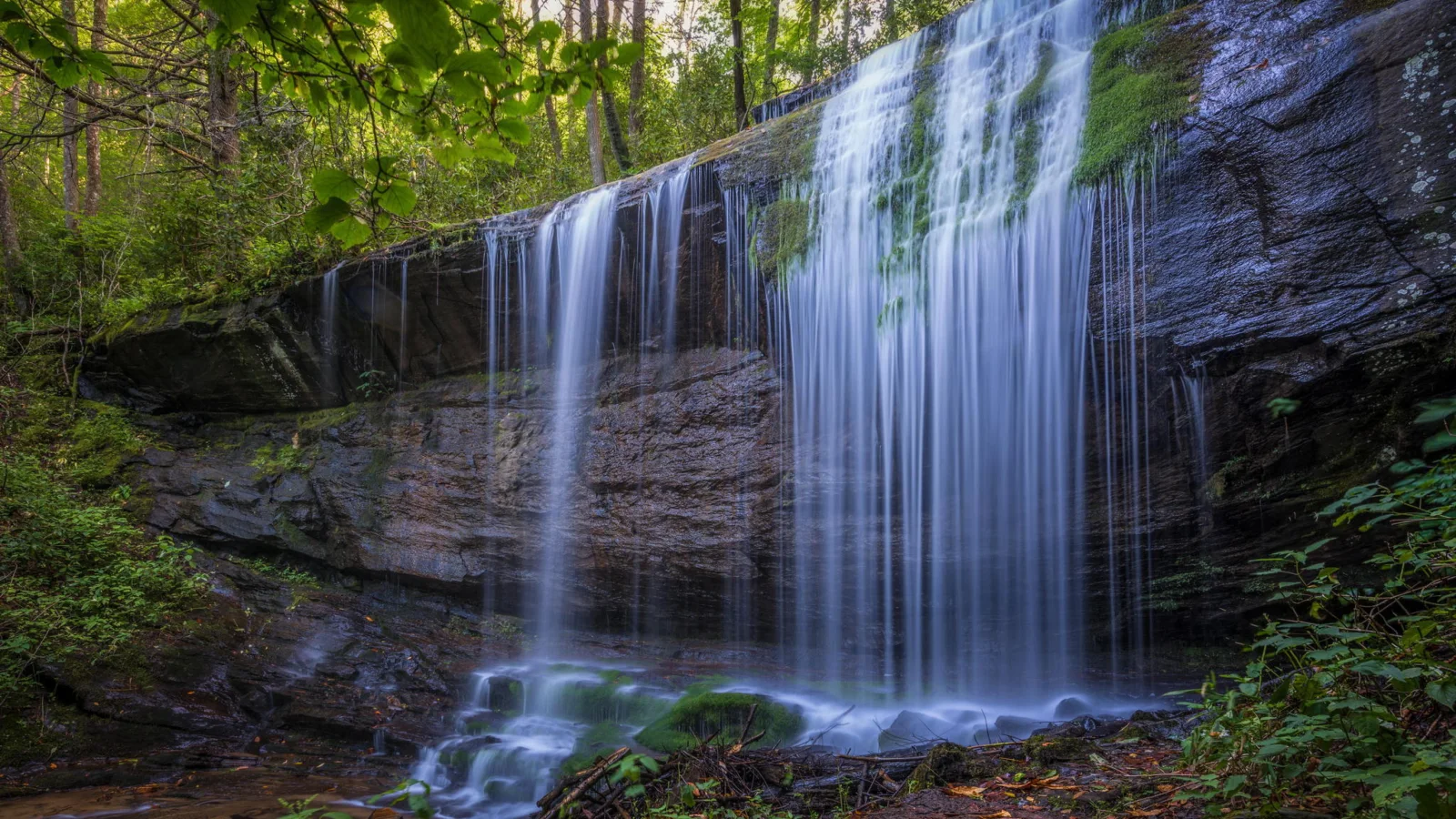Kalte Wasser Wasserfall fließt entlang Nasser Felsen