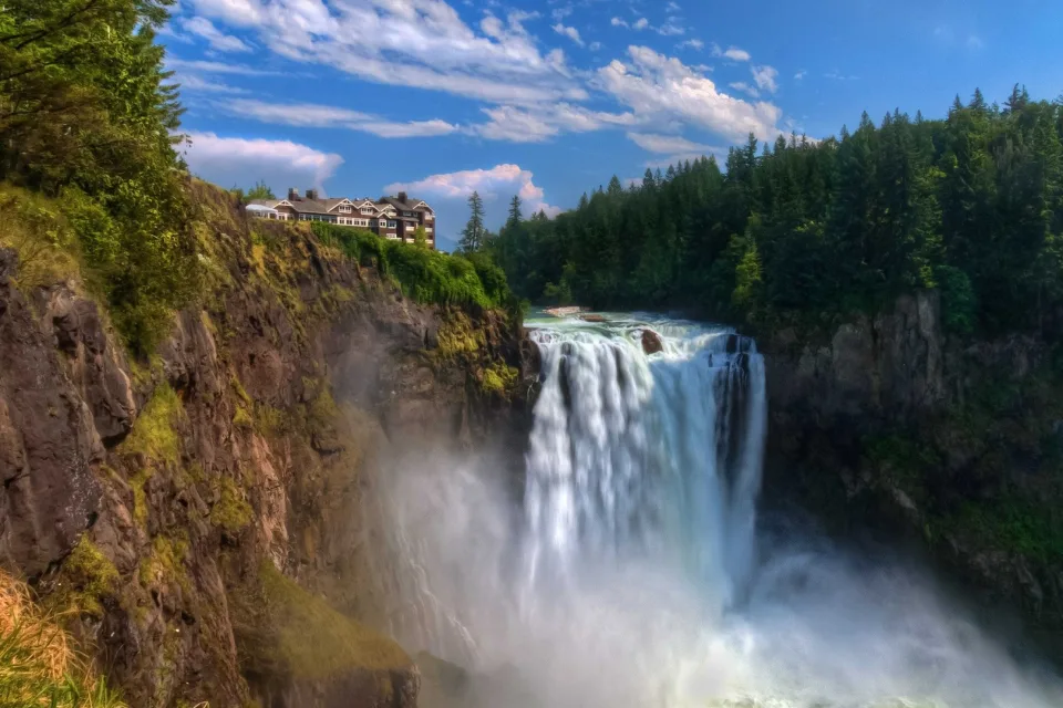 Schnelles Wasser Wasserfall fließt mit Klippen bei Nadelbaum Wald