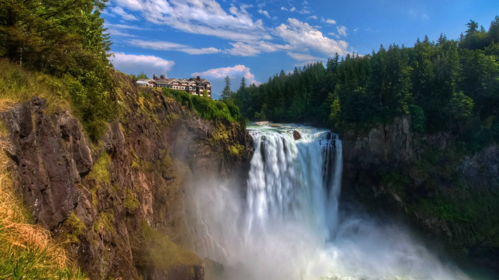 Schnelles Wasser Wasserfall fließt mit Klippen bei Nadelbaum Wald
