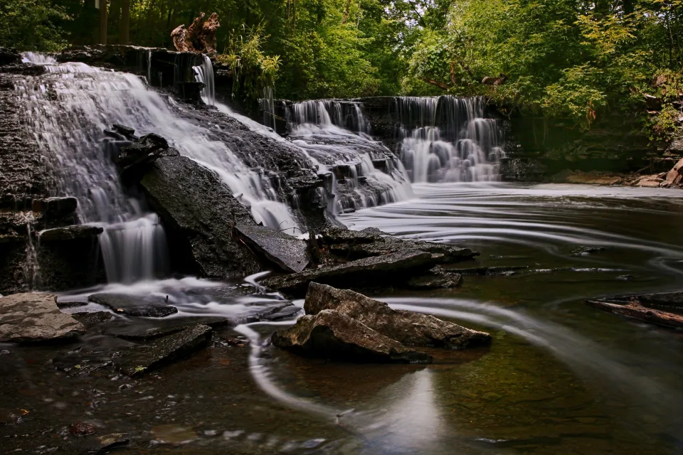 Schnelles Wasser fließt über Felsen Wasserfall im Park