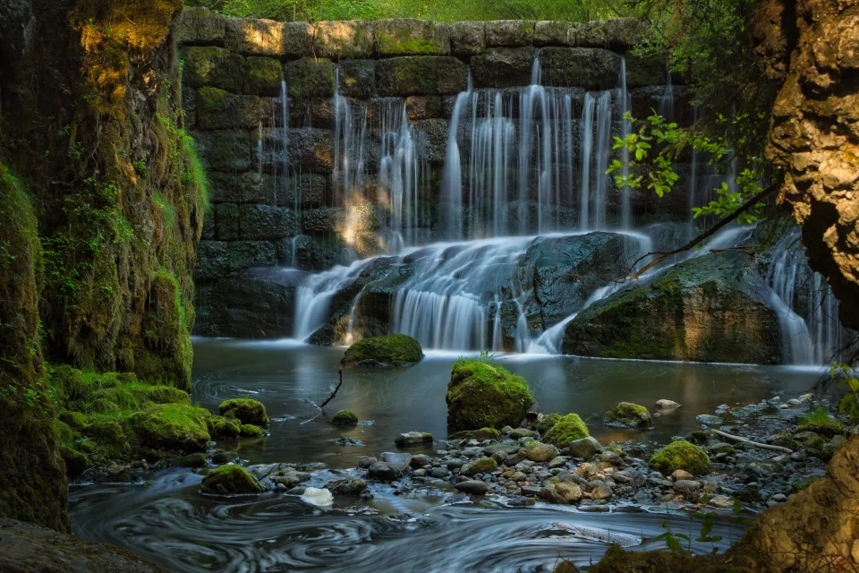 Wasserfall dringt durch durch bedeckte Moos Felsen
