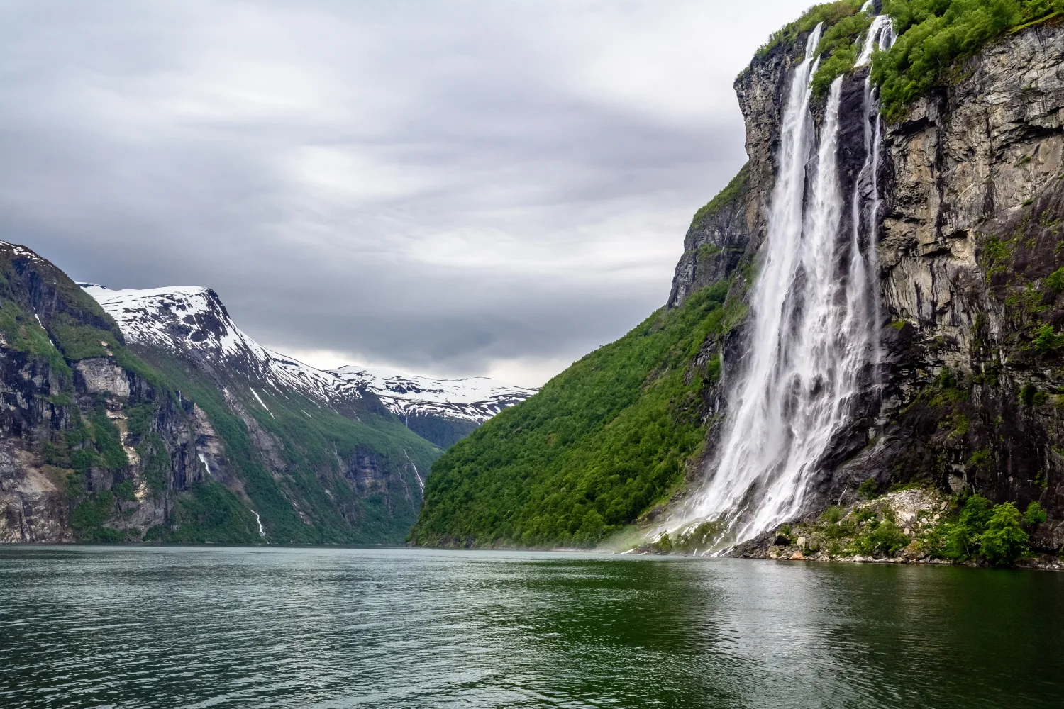 Wasserfall fließt mit Klippen in See, Norwegen