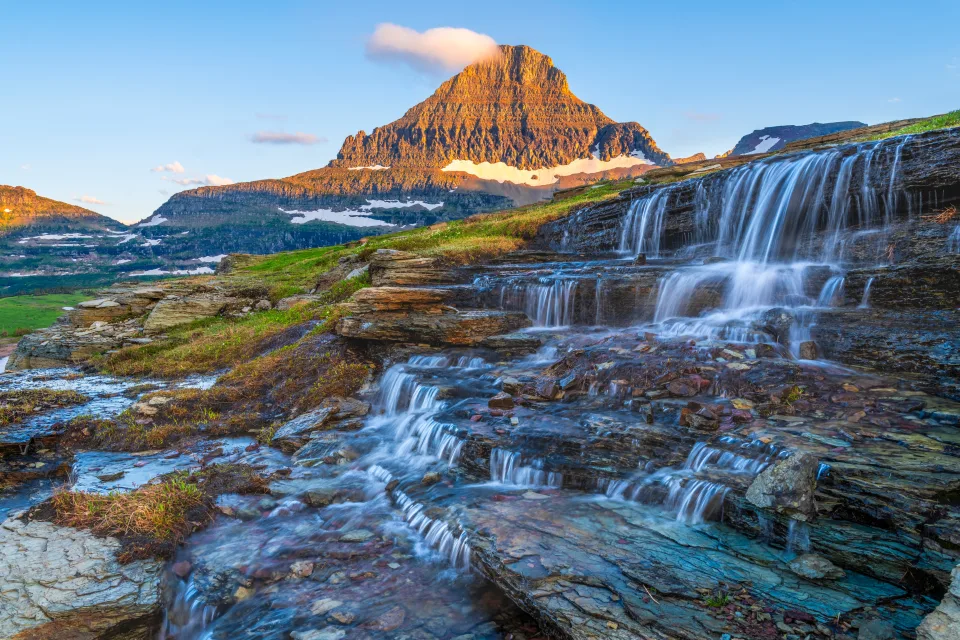 Wasserfall fließt über Steine bei hohen Berge