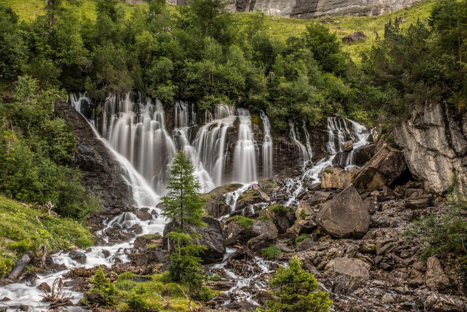 Wasserfall fließt über Steine, Schweiz