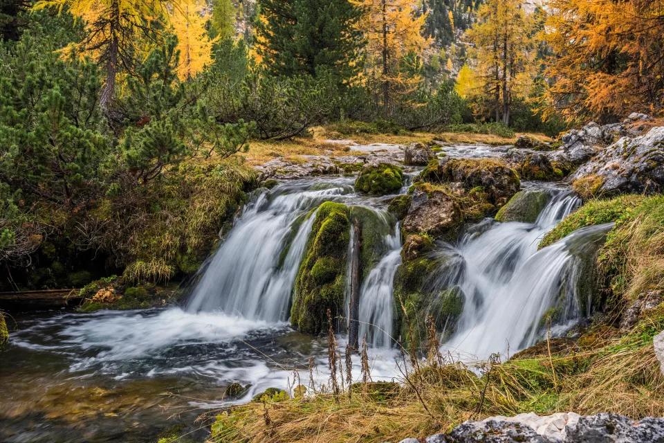 Wasserfall zwischen Felsen im Herbstwald