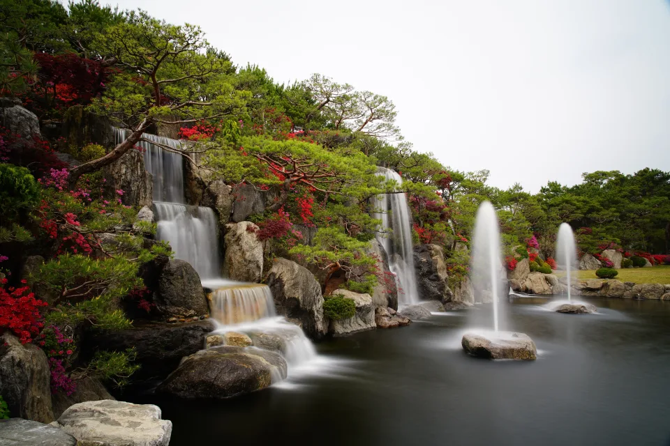Wasserfälle in schönem Garten mit grünen Baum