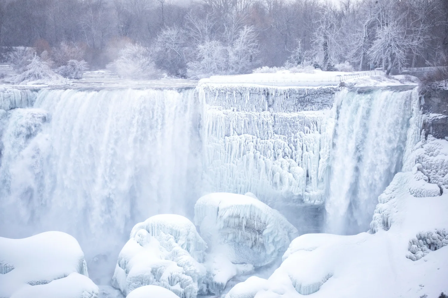 Zugefrorener Wasserfall fließt über Steine im Winter