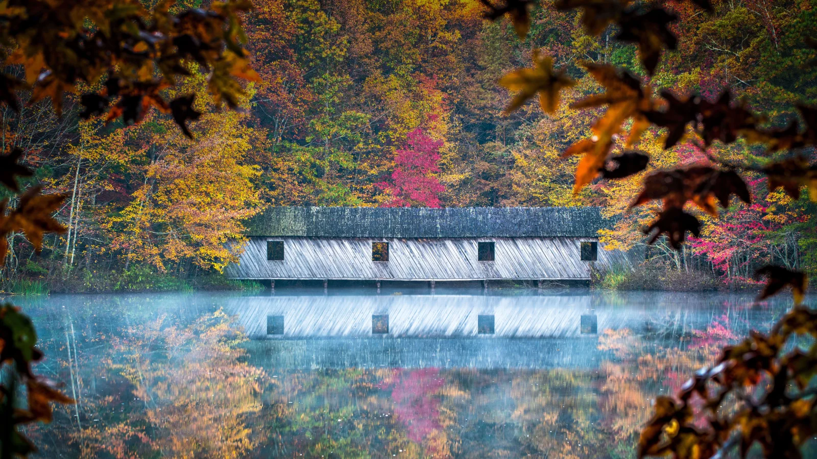 Haus spiegelt sich im See im Herbst