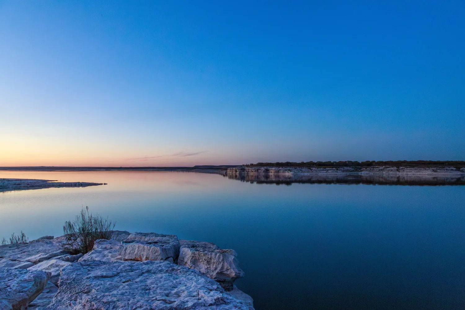 Hellblauer Himmel über dem Wasser bei Sonnenaufgang