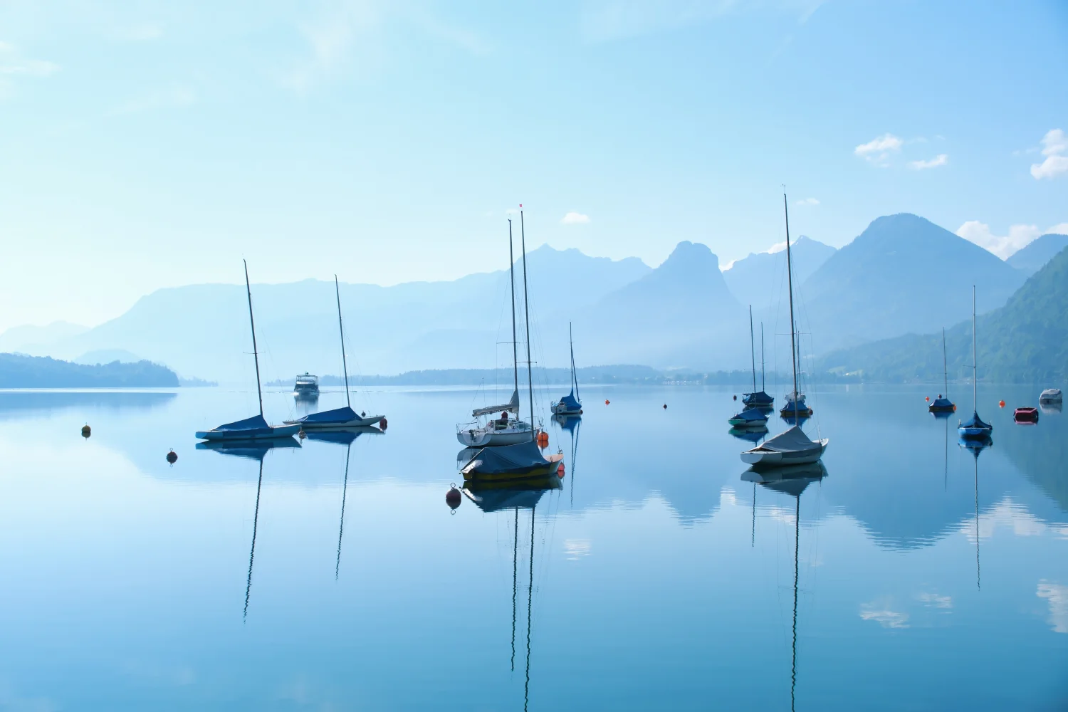 Boote am See bei Berg bei Sonnenaufgang im Nebel
