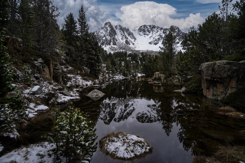 Kalte Wasser in See mit großen Felsen vor einer Bergkulisse