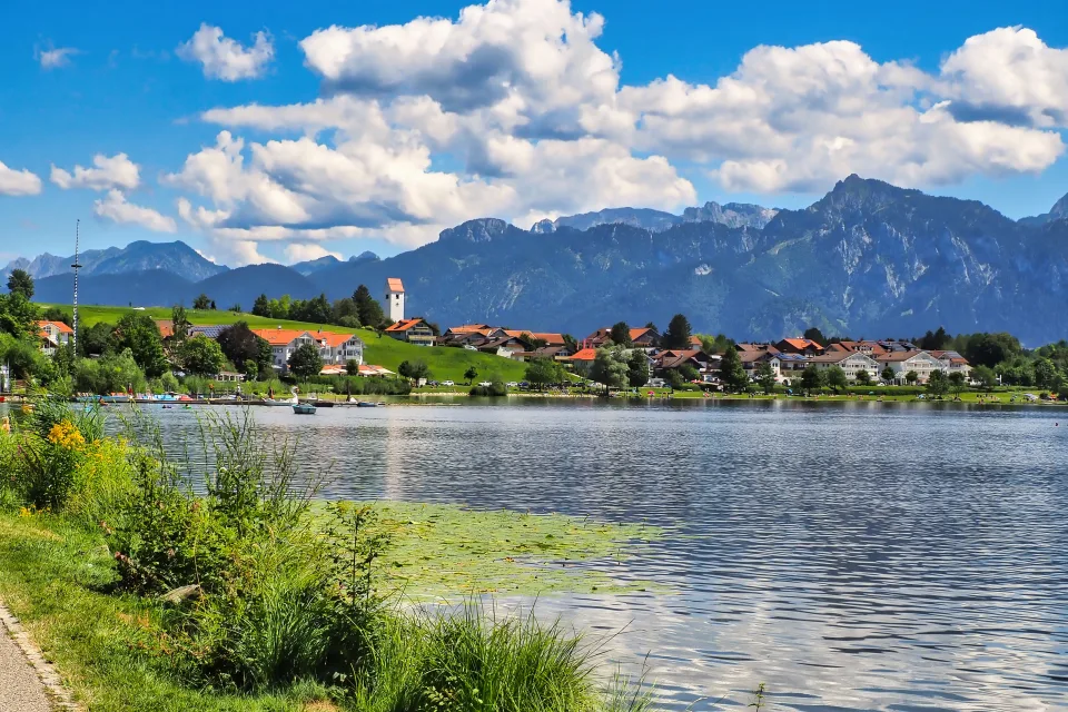 Schöner Blick auf See und Berge unter hellblauem Himmel mit weißen Wolken