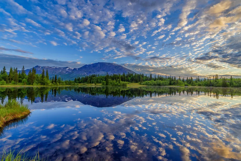 Schöner Himmel mit Wolken spiegelt sich im See bei Berg