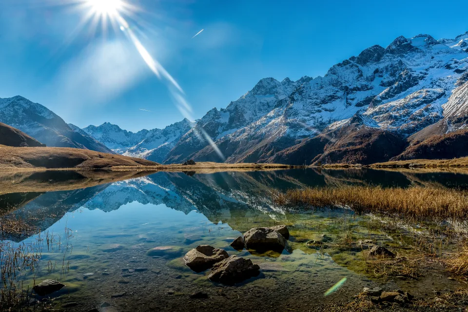 Strahlen leuchtenden Sonne beleuchten Berg und See