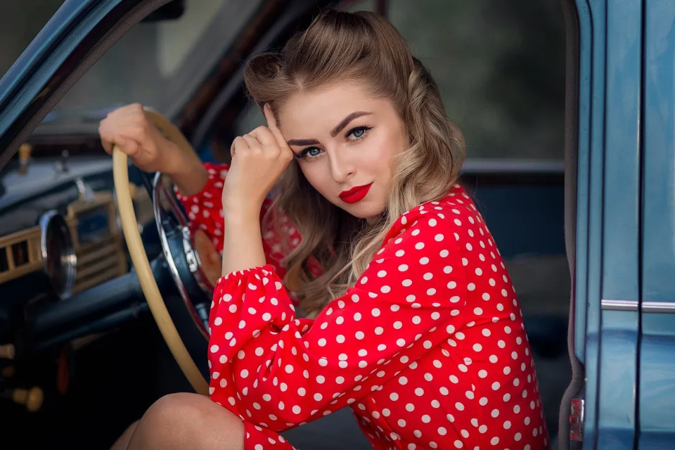 Blauäugige Frau im Retro Stil am Steuer eines Autos