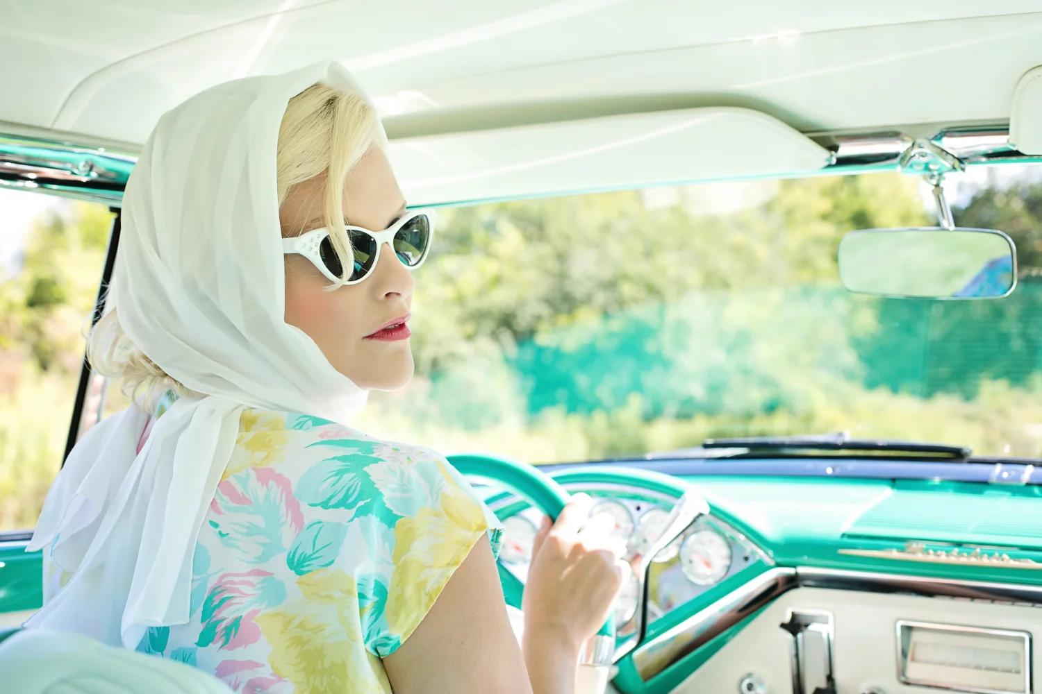 Frau im Retro Stil in Brille in altem Auto