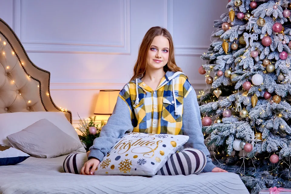 Hübsche Frau auf Bett am Weihnachtsbaum