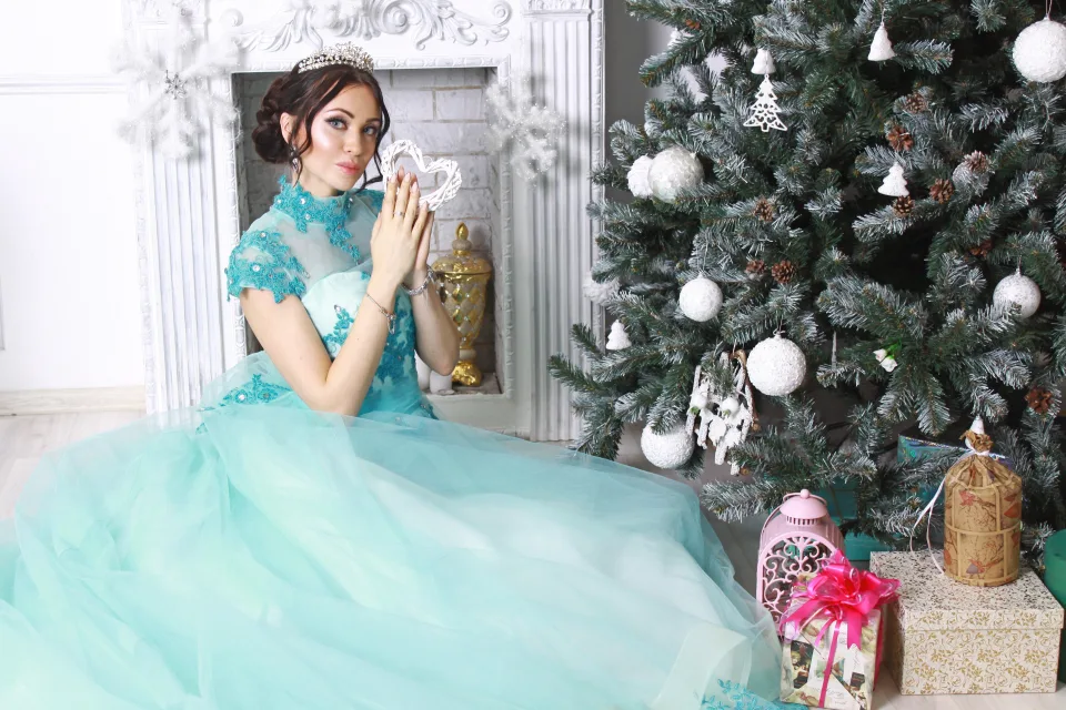 Junge Frau in schönem hellblauem Kleid am Weihnachtsbaum
