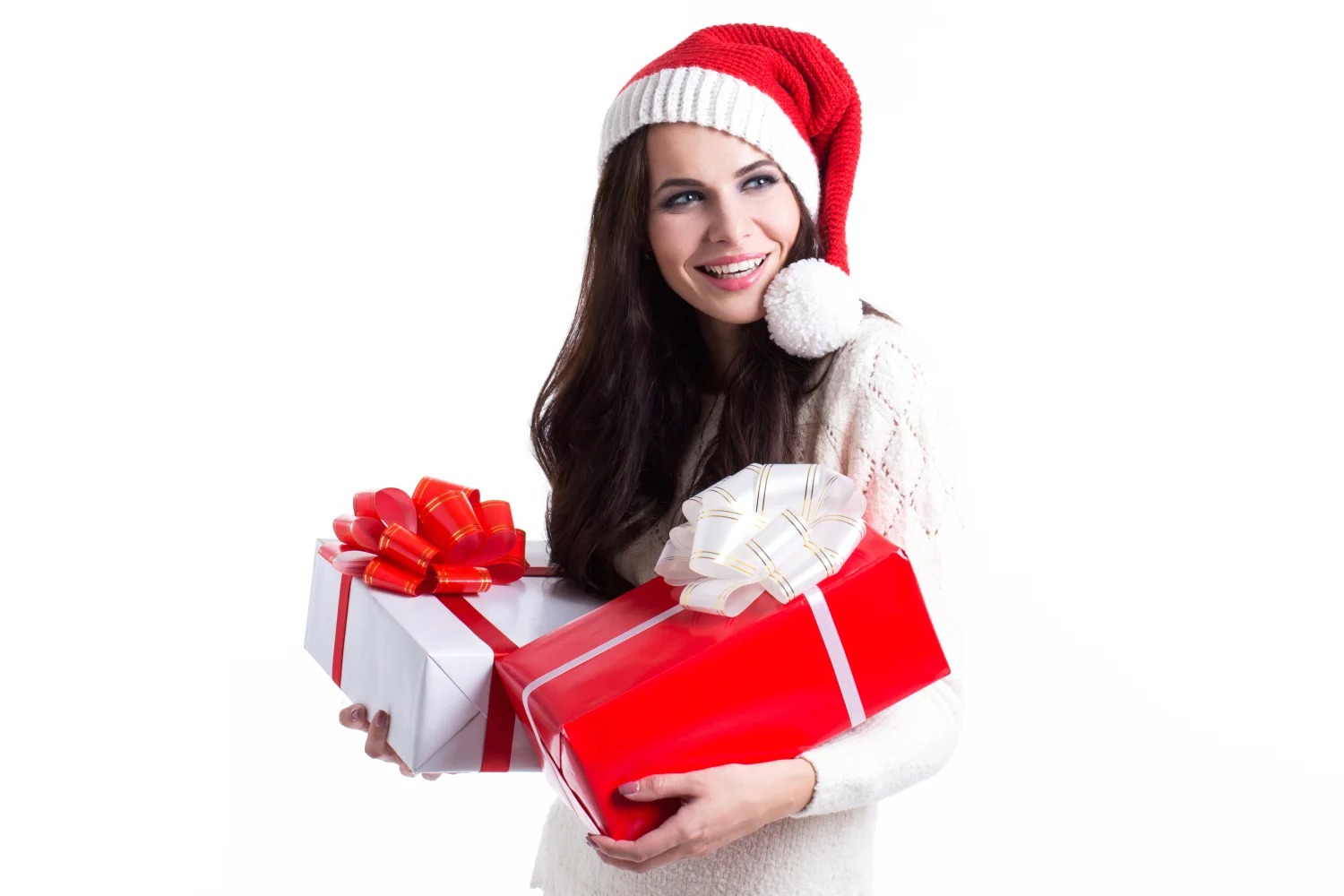 Lächelnde Frau mit Weihnachtsmütze mit Geschenken vor weißem Hintergrund