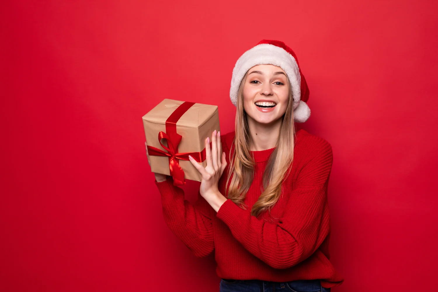 Lächelnde Frau mit einem Geschenk im festlichen Kostüm