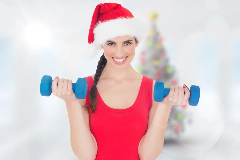 Schöne Frau in Mütze Weihnachtsmann Claus mit einem Gegenstand in den Händen