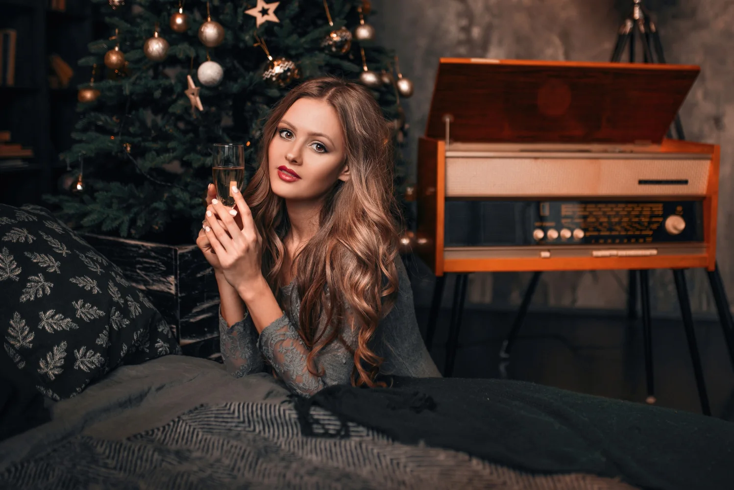Schöne Frau mit Champagner am Weihnachtsbaum