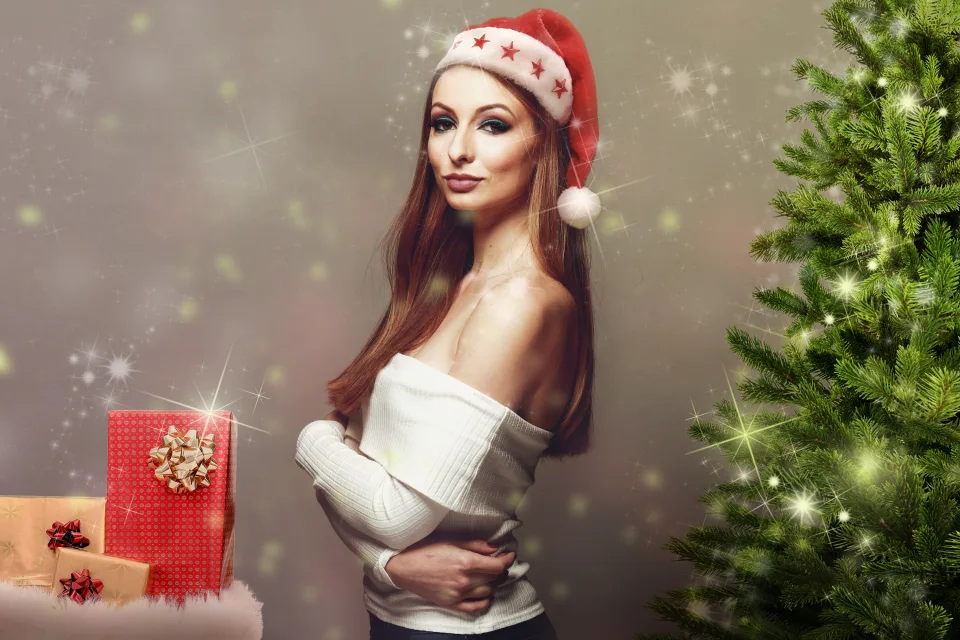 Schöne Frau mit Geschenken am Weihnachtsbaum