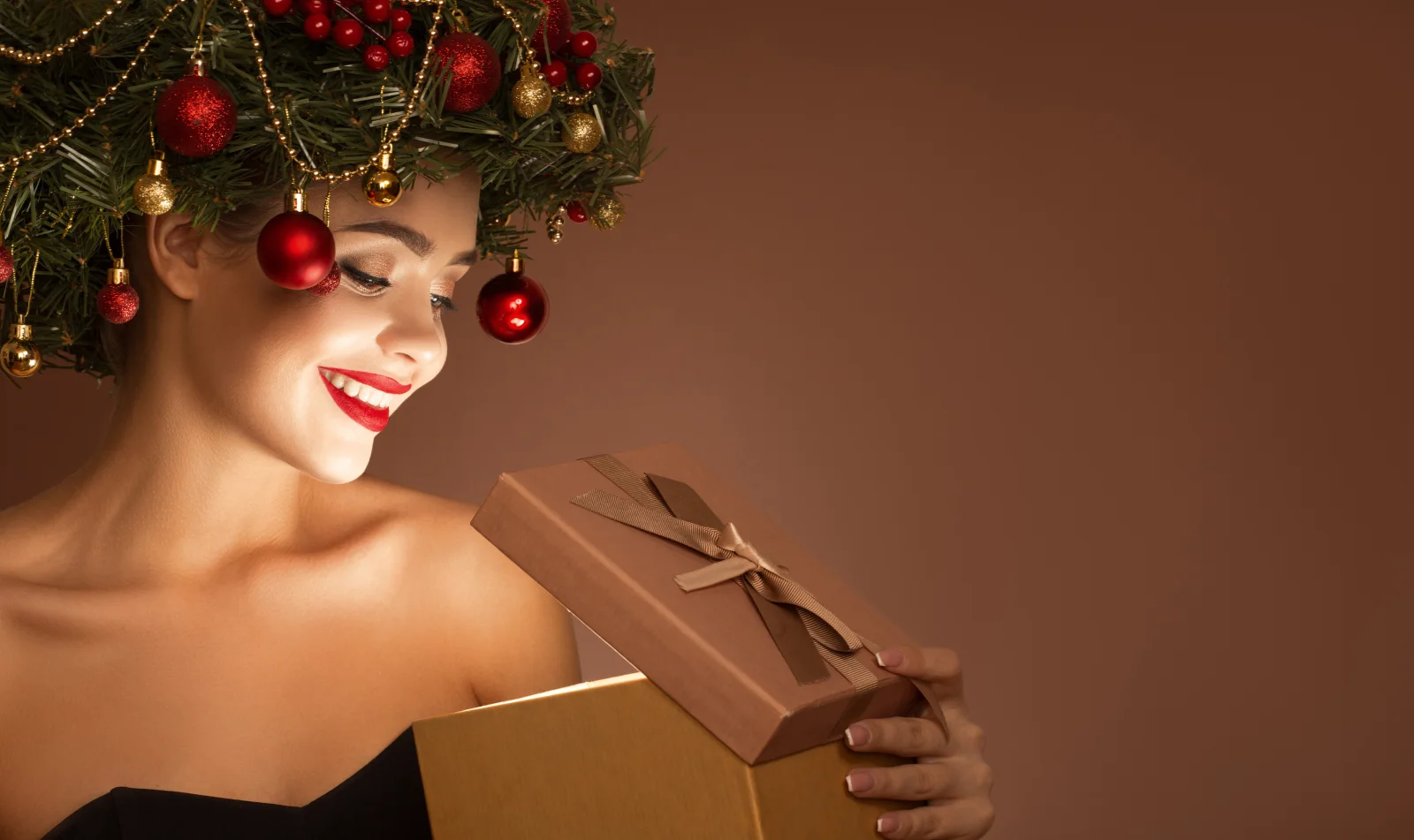 Schöne Frau mit weihnachtlichen Kranz auf Kopf mit einem Geschenk