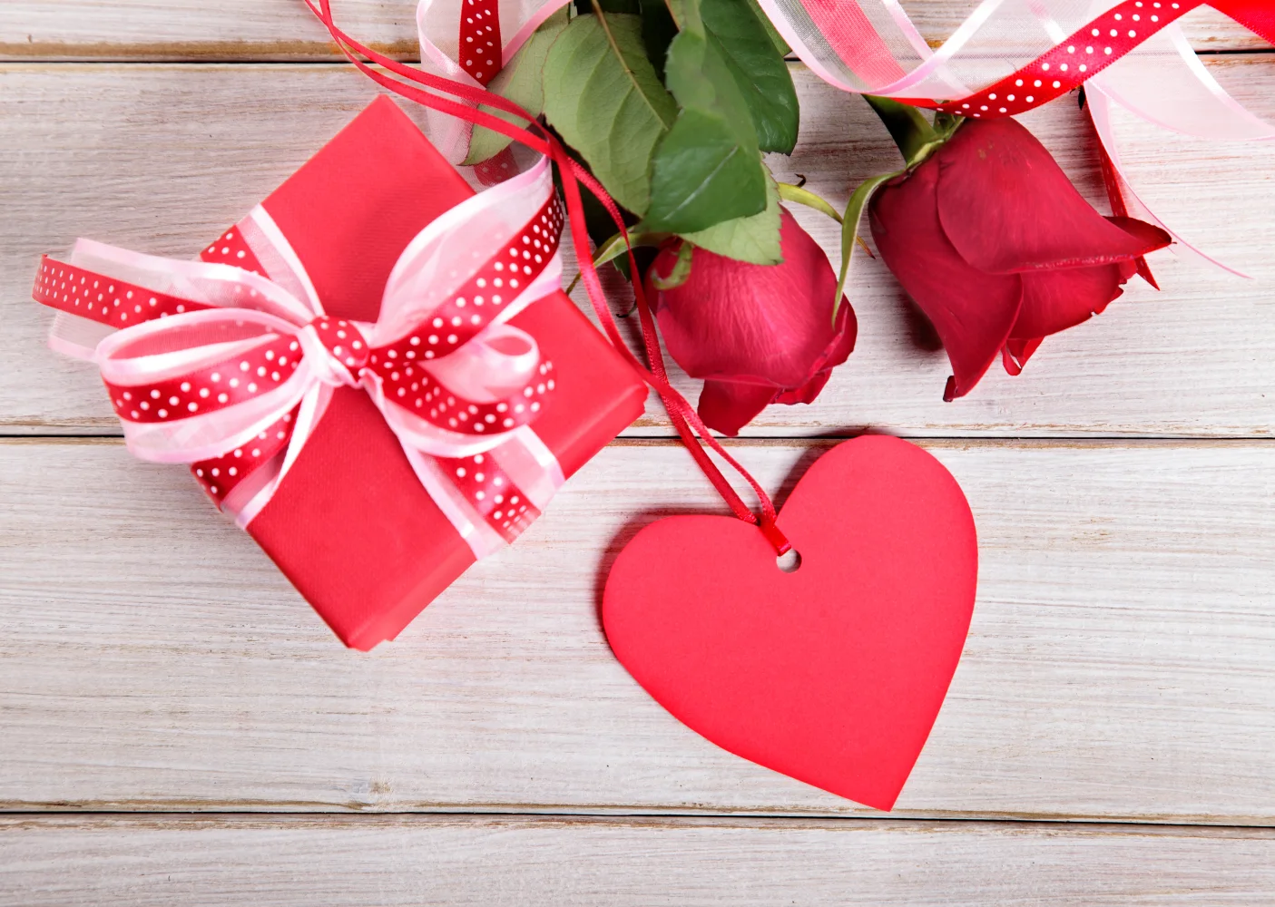 Geschenk und rotes Herz mit Rose für