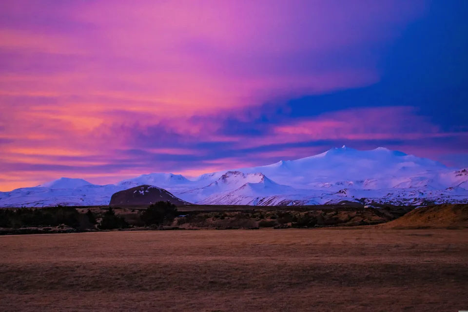 Bedeckte weißem Schnee Berge vor dem Hintergrund rosa Himmel