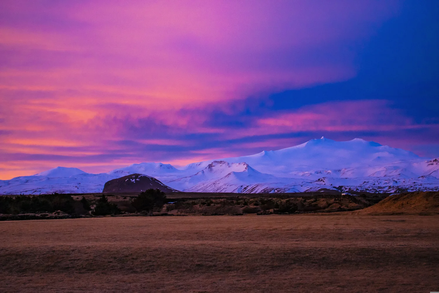 Bedeckte weißem Schnee Berge vor dem Hintergrund rosa Himmel