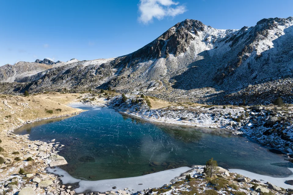 Bedecktes Eis See in verschneiten Berge im Sonnenlicht, Andorra