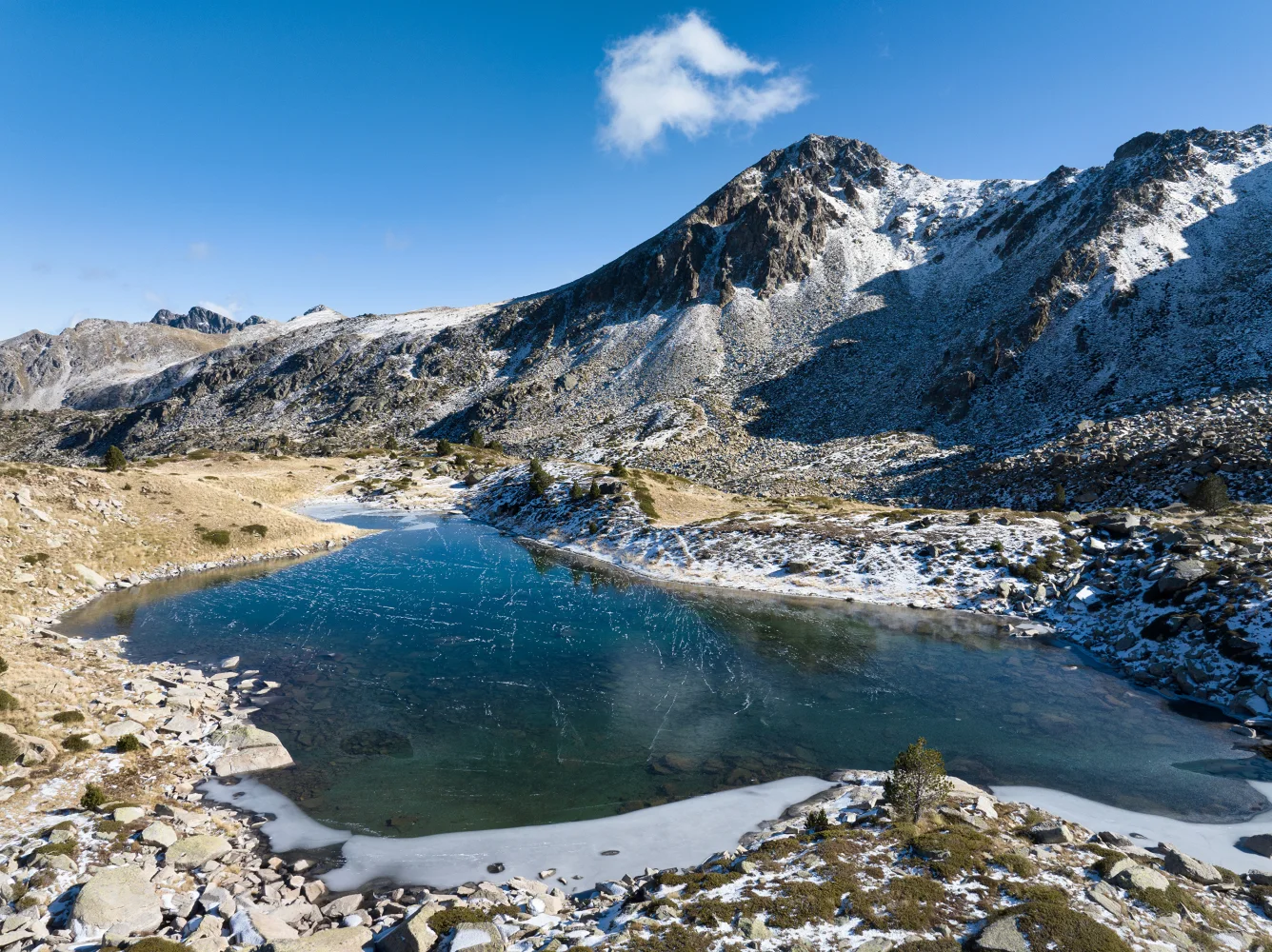Bedecktes Eis See in verschneiten Berge im Sonnenlicht, Andorra