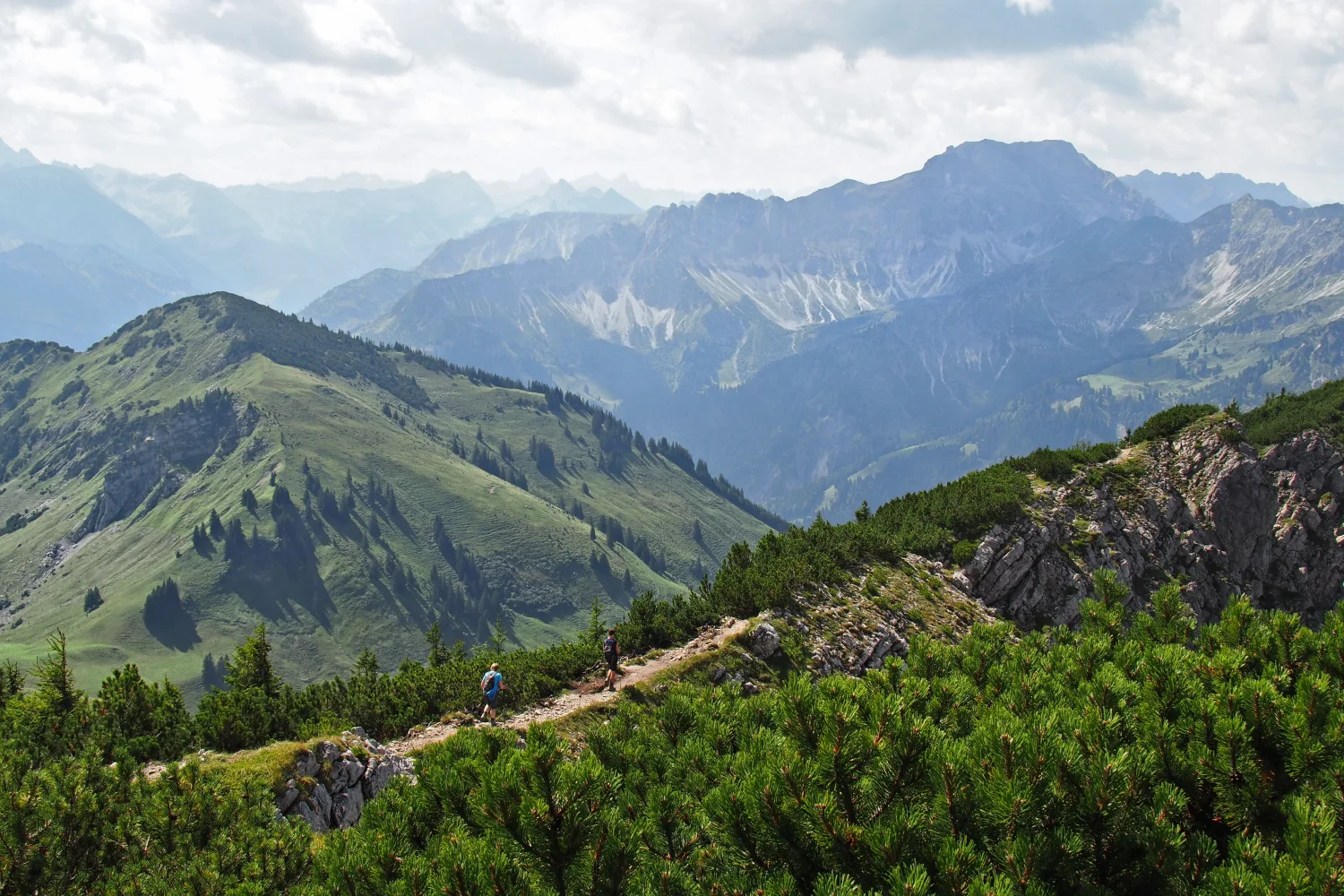 Blick auf hohe bedeckte Grün Berge unter weißen Wolken