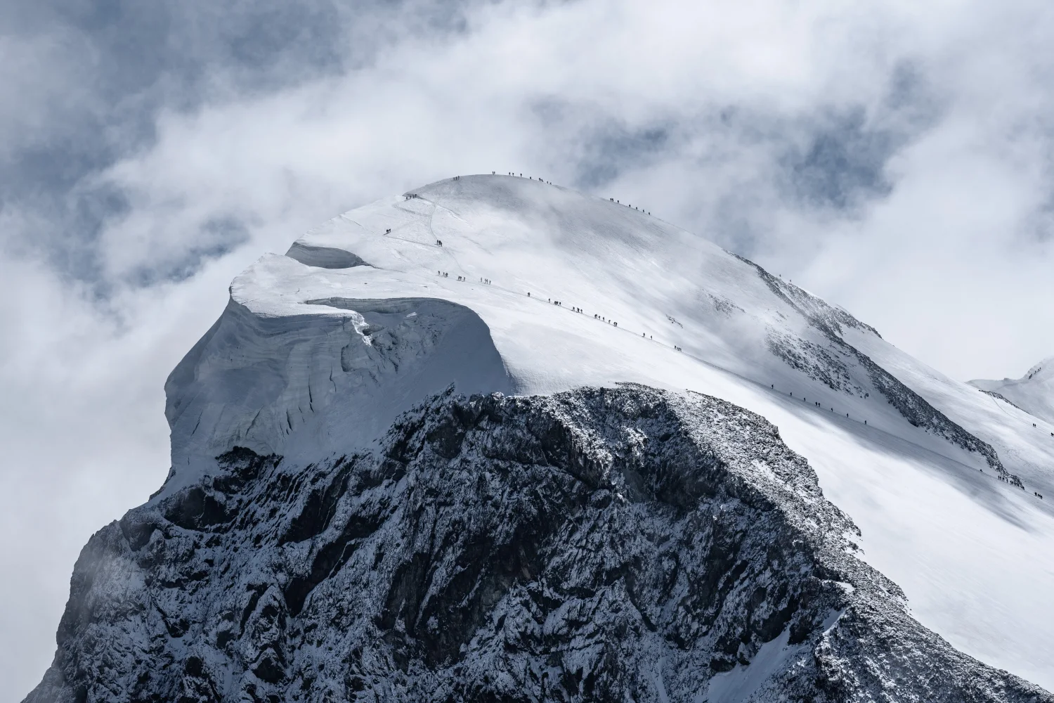 Blick auf verschneite Gipfel Berge unter weißen Wolken