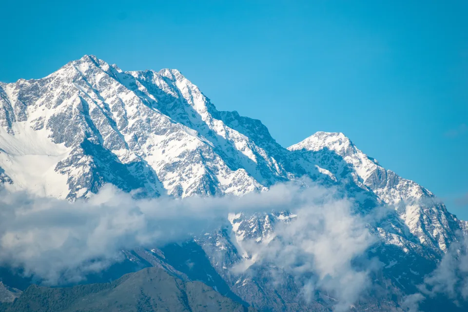 Hohe schneebedeckte Berge vor hellblauem Himmel