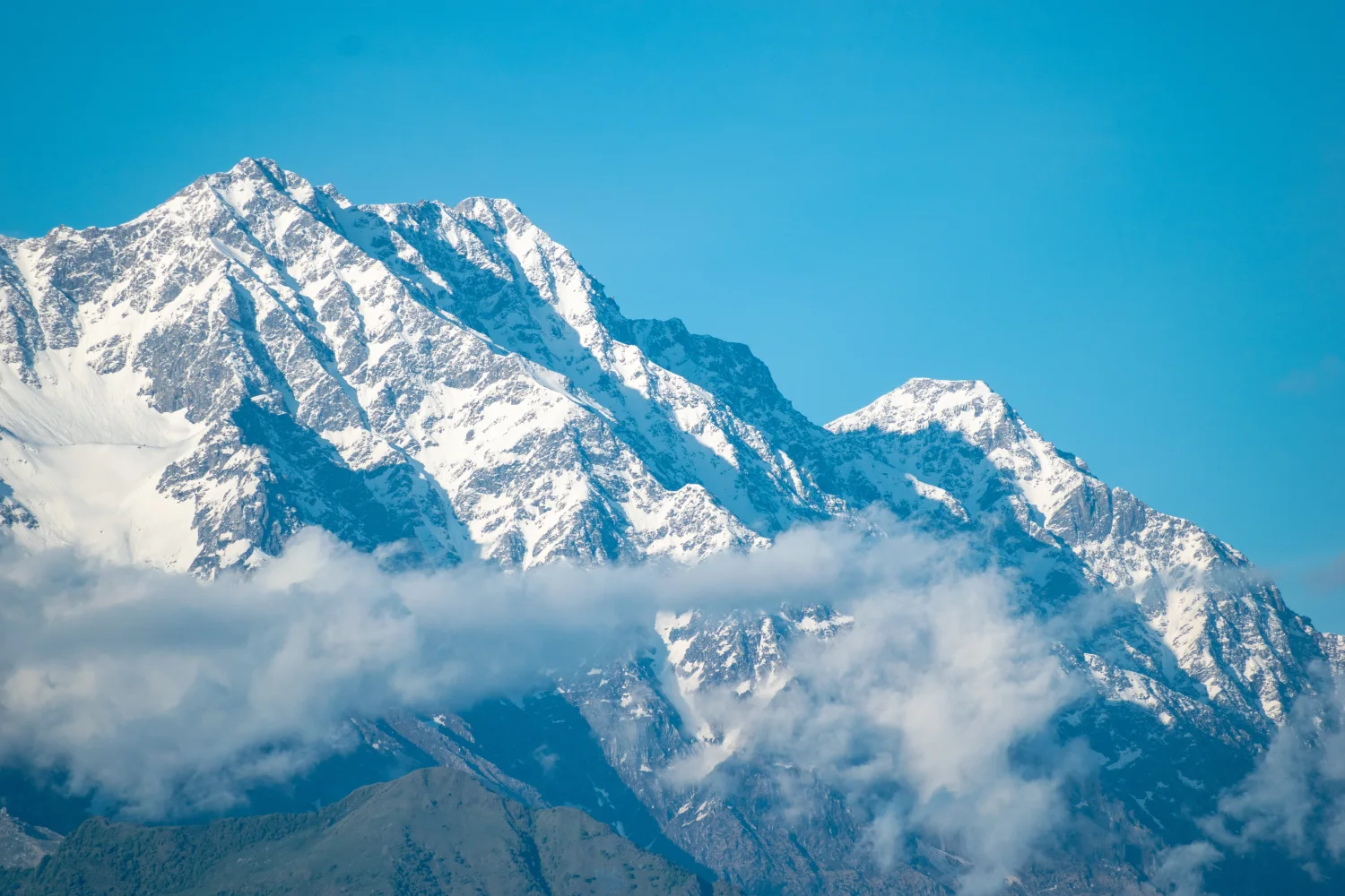 Hohe schneebedeckte Berge vor hellblauem Himmel