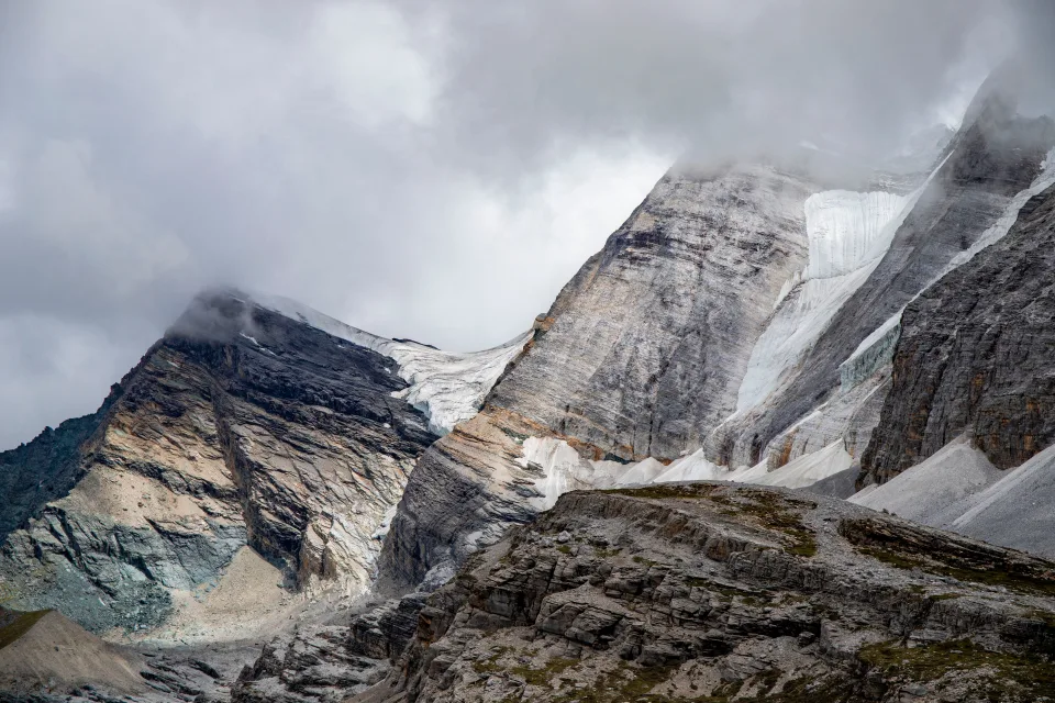 Hohe steinerne Berge in weißen Wolken