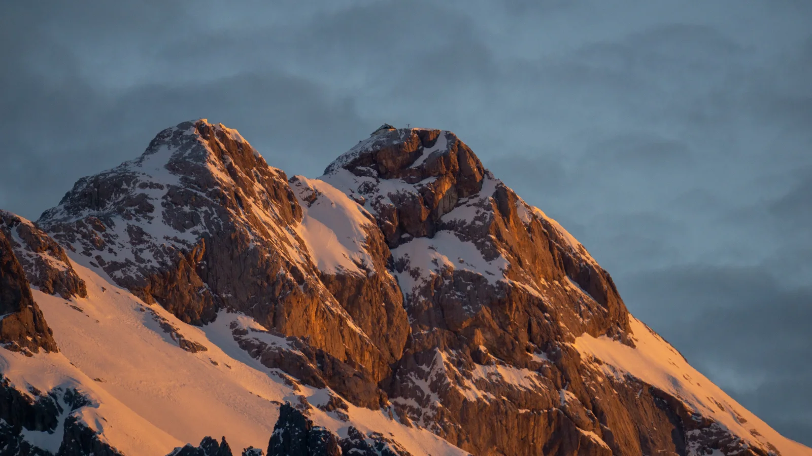 Hohe verschneite Berge unter Gewitter Himmel