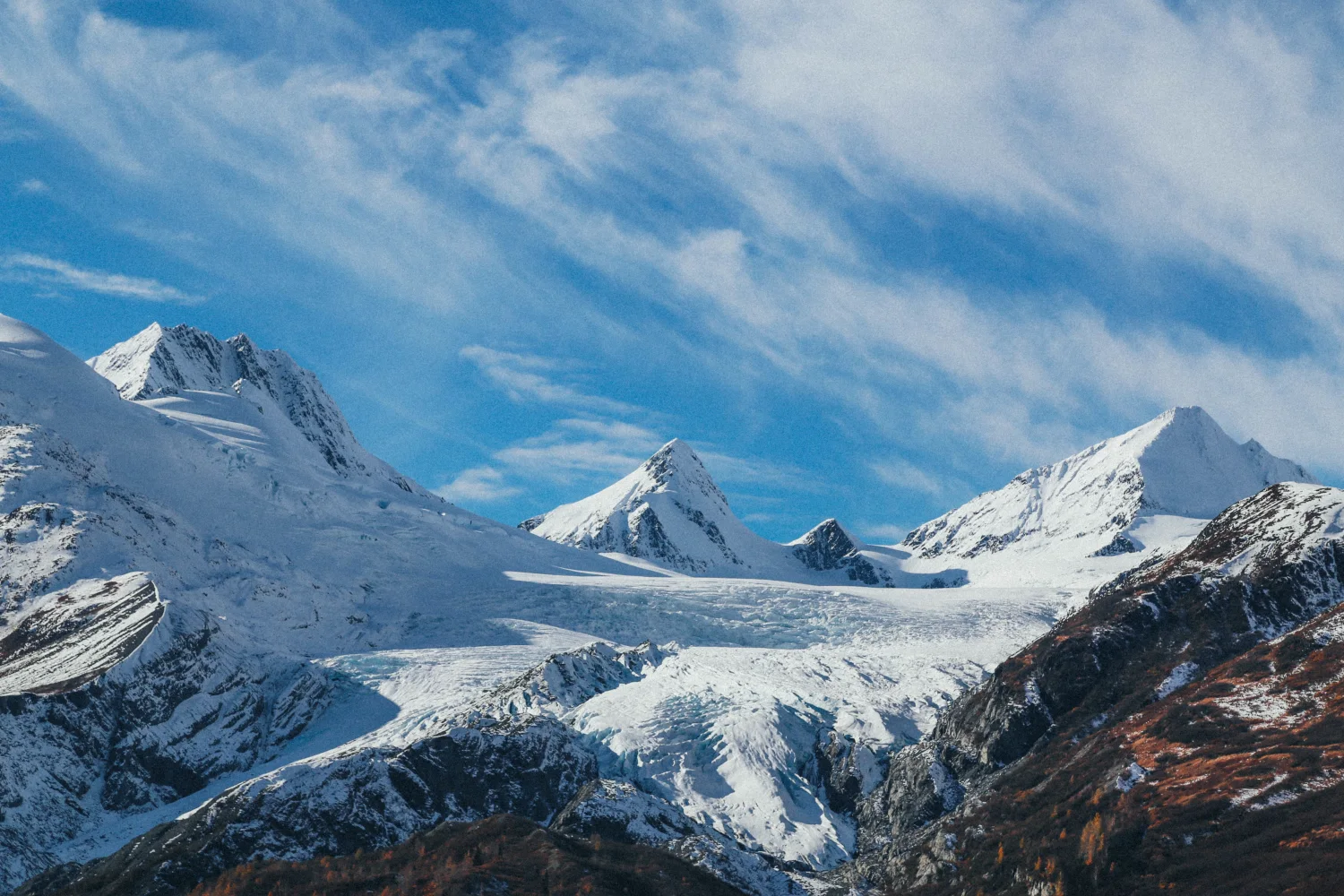 Hohe verschneite Berge unter hellblauem Himmel