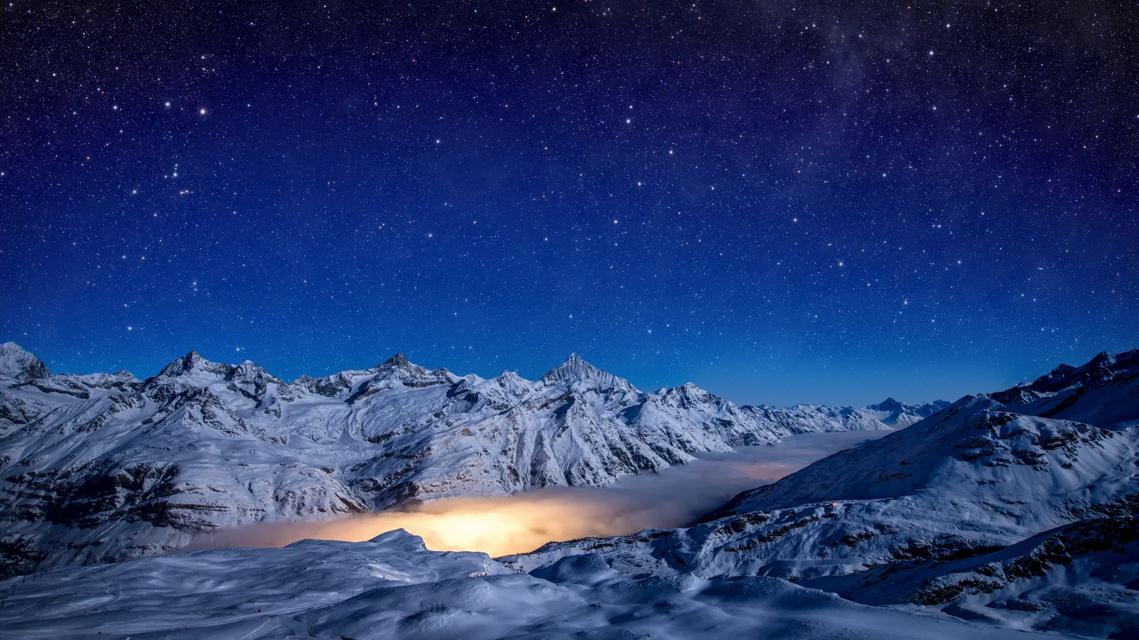 Schönes nächtliches Himmel über bedeckten Schnee Berge
