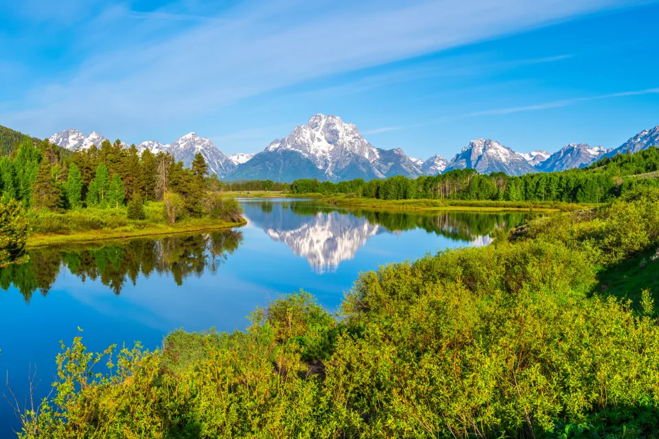 Stiller Fluss vor einer Bergkulisse im Nationalpark Grand Teton