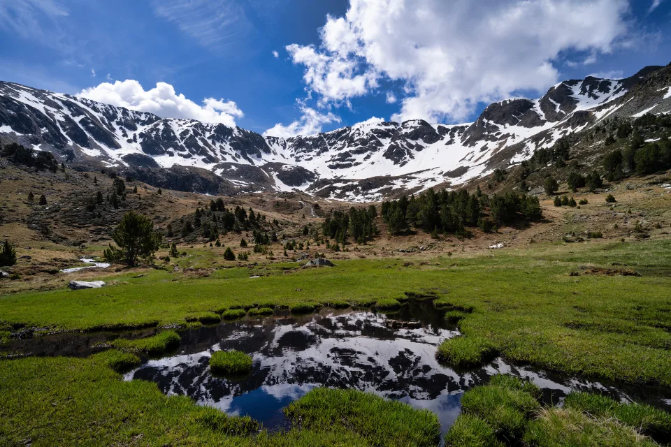Weiße Wolken über verschneiten Berge am Fluss, Andorra