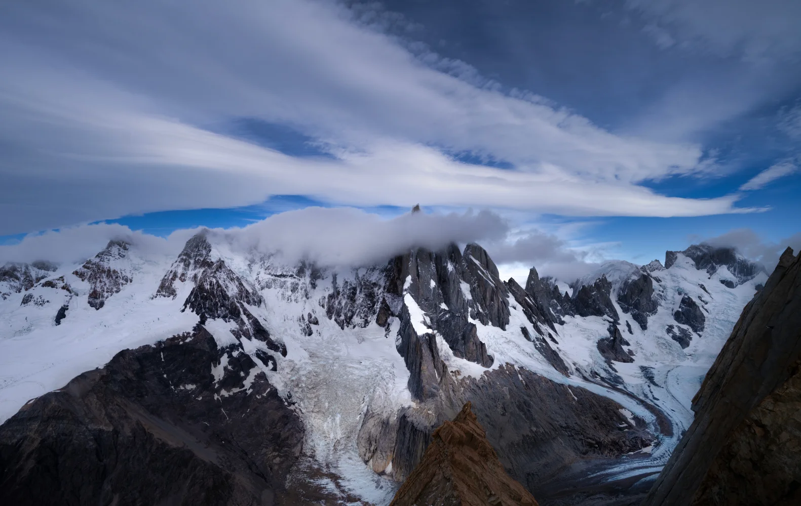 Weiße Wolken über verschneiten Berge