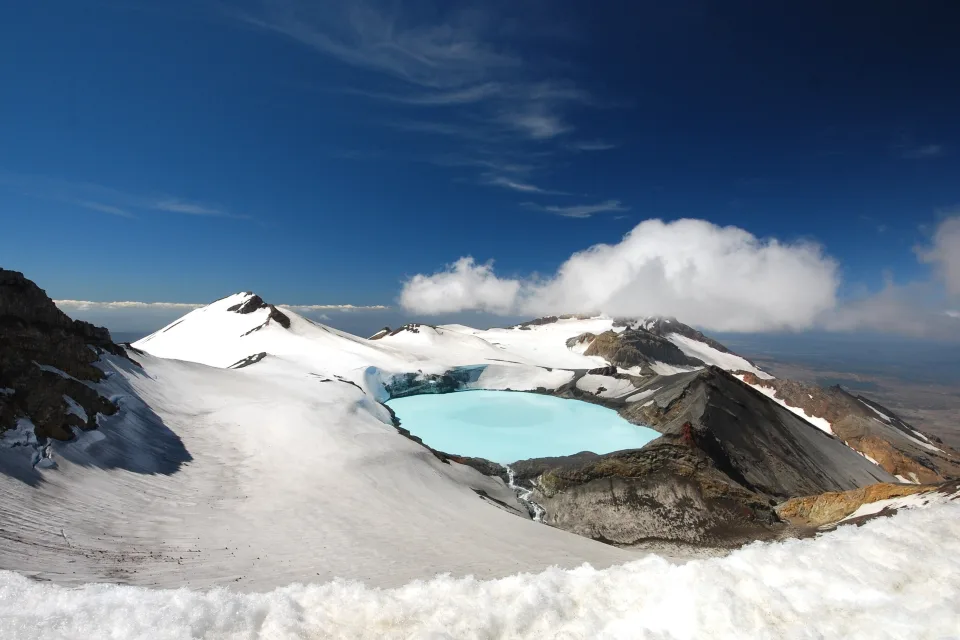 Verschneiter Krater Vulkan unter hellblauem Himmel, neue Seeland