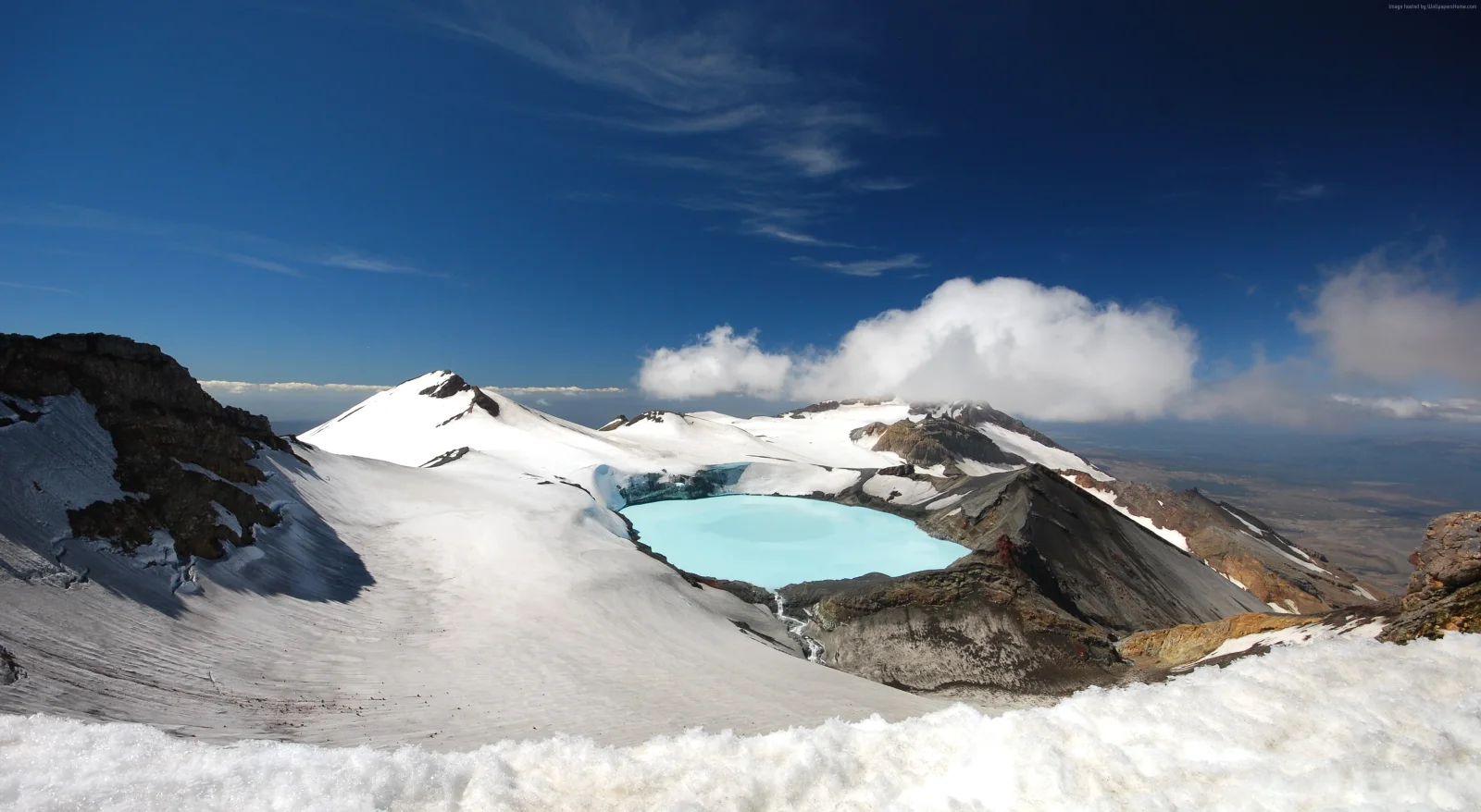 Verschneiter Krater Vulkan unter hellblauem Himmel, neue Seeland